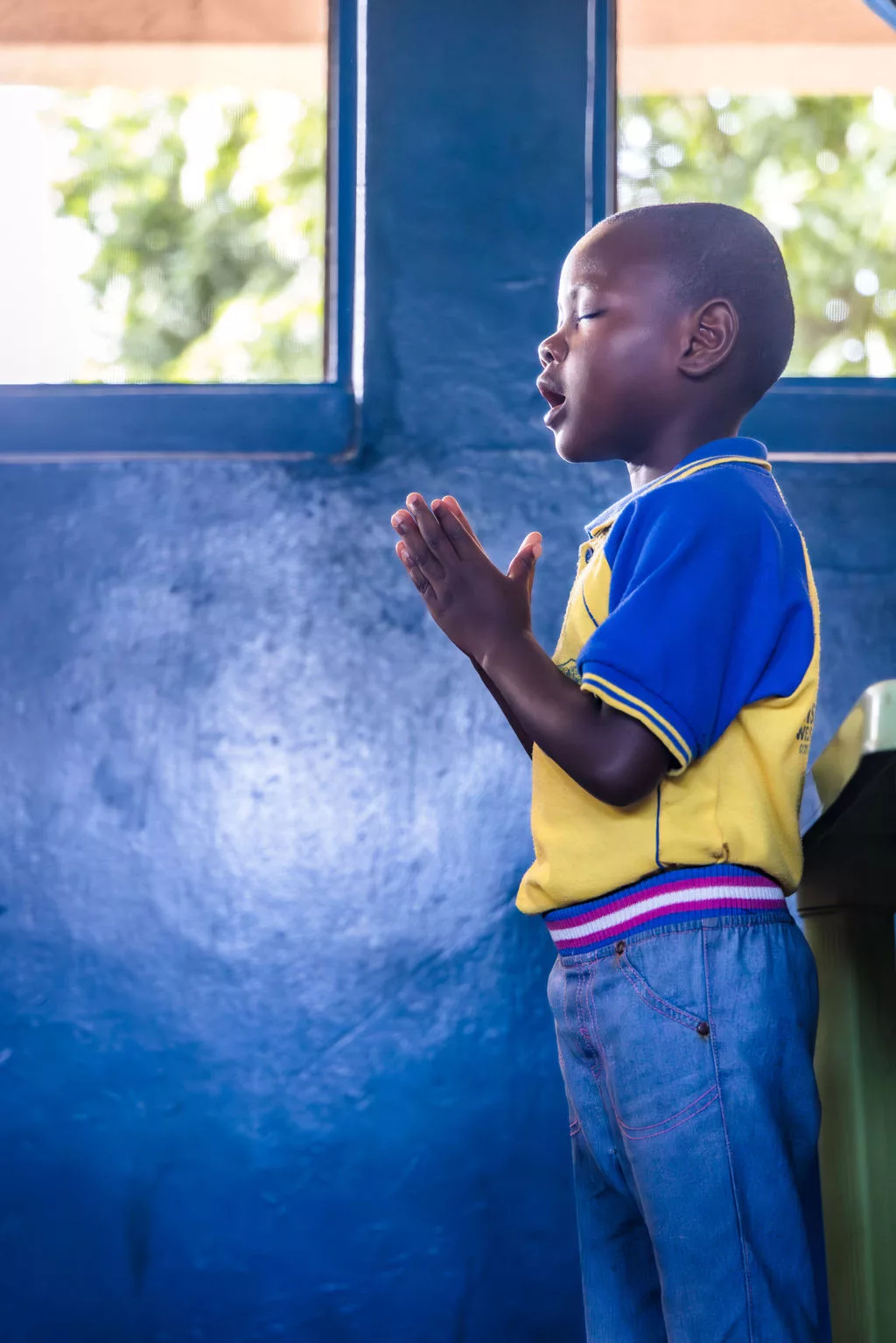 Nigerian child sings during school prayer service - Vision Africa. 