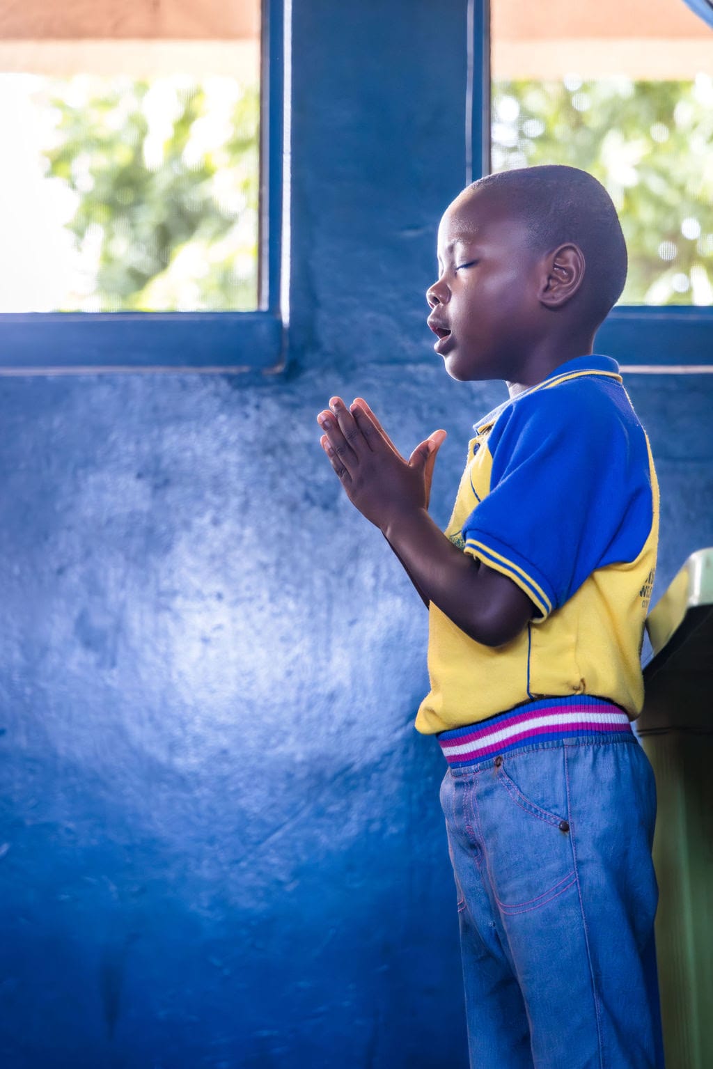 Little girl prays with her eyes closed. Vision African's Thanksgiving Message 2024